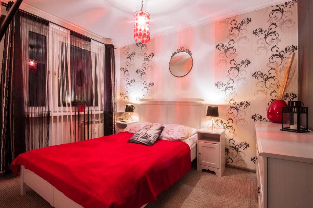 a bedroom with a red bed with a red blanket at Apartament Słoneczna in Zakopane