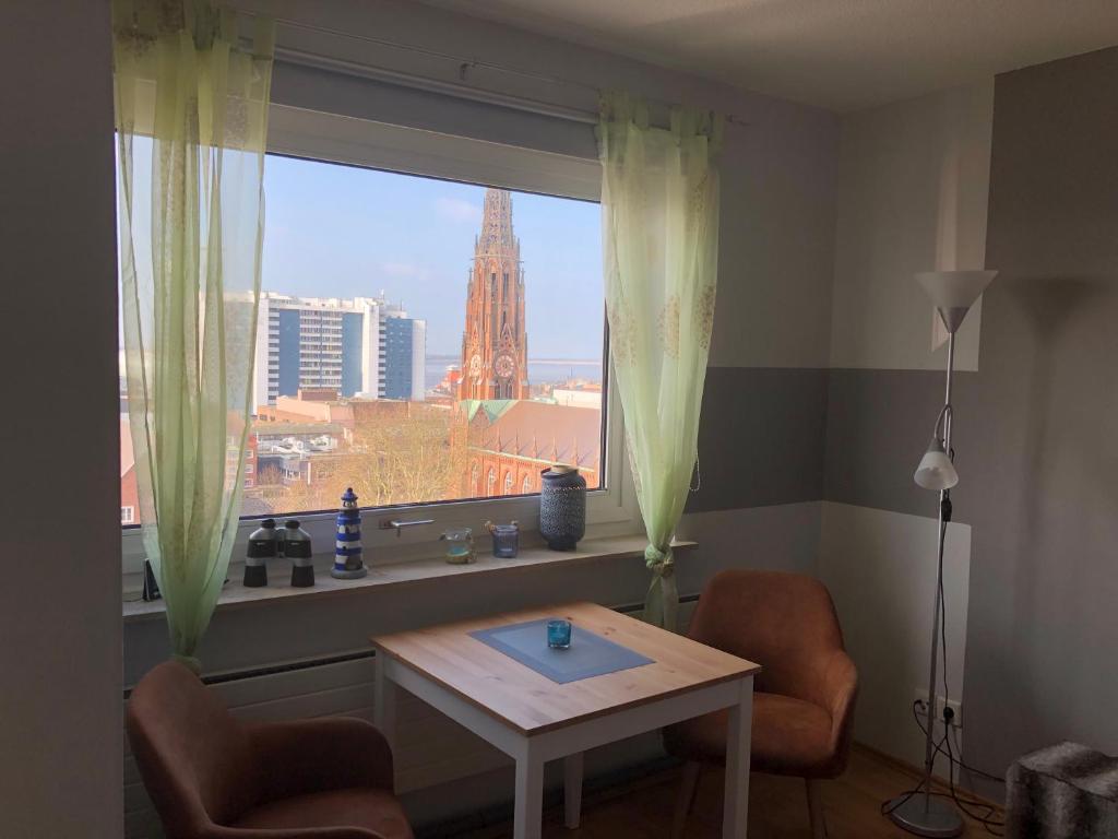 een kamer met een tafel en een raam met uitzicht bij City Weserblick in Bremerhaven