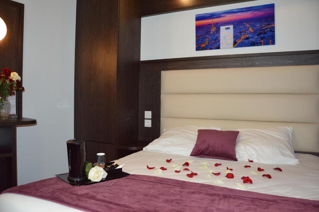 ein Schlafzimmer mit einem Bett mit Rosen darauf in der Unterkunft Parc Hotel in Paris