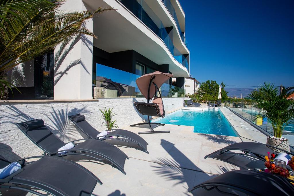 a swimming pool with lounge chairs and a building at Villa Valis in Baška