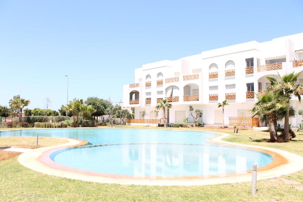 una piscina frente a un edificio en Hara Appart Luxe famille uniquement en Saidia 