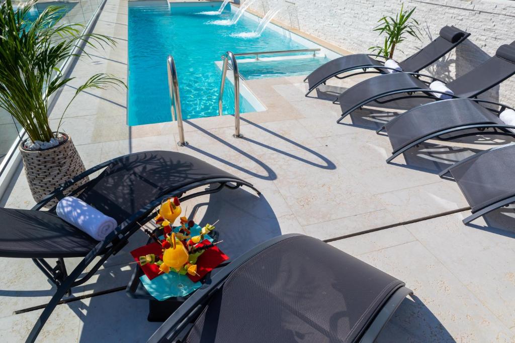 a row of chairs and a swimming pool at Villa Valis in Baška