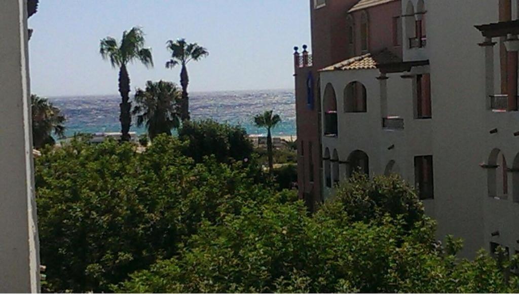 vistas a un edificio, a las palmeras y al océano en BONITO APARTAMENTO EN ZAHARA DE LOS ATUNES, en Zahara de los Atunes