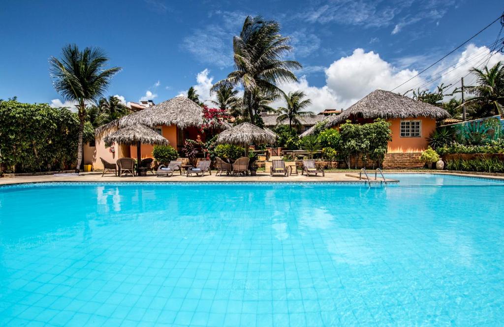 a swimming pool in front of a resort at Pousada Tranquilandia Village in Canoa Quebrada