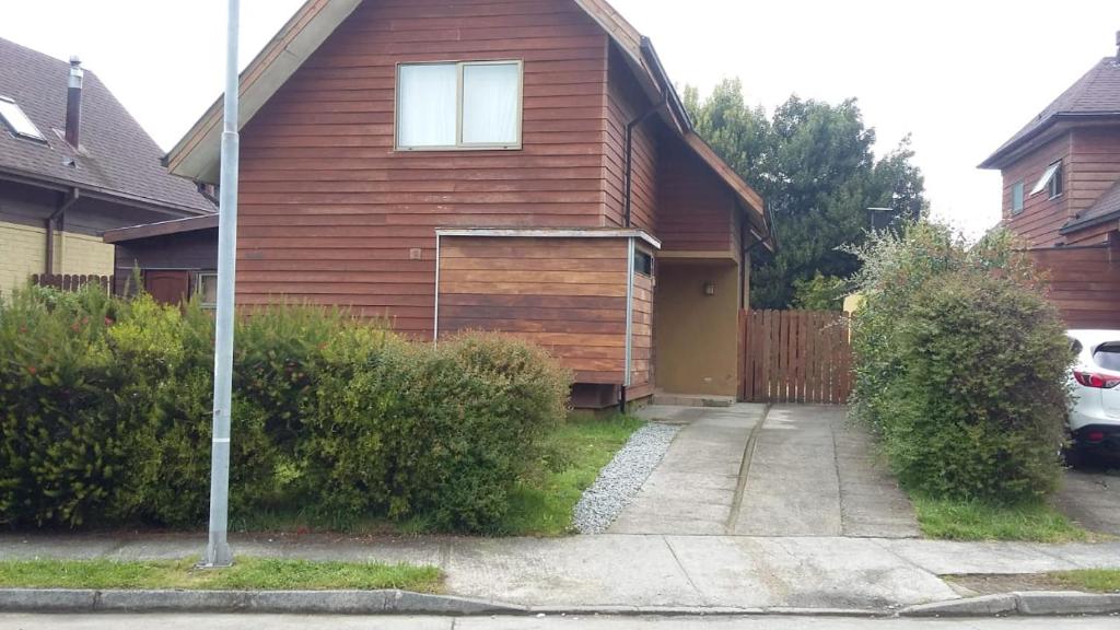 una casa de madera con un coche aparcado delante de ella en Borde lago I - II -III, en Puerto Varas