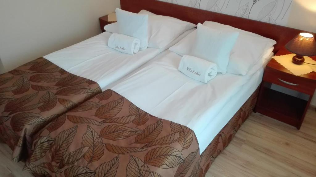 1 cama con 2 almohadas en una habitación en Villa Amber, en Grzybowo