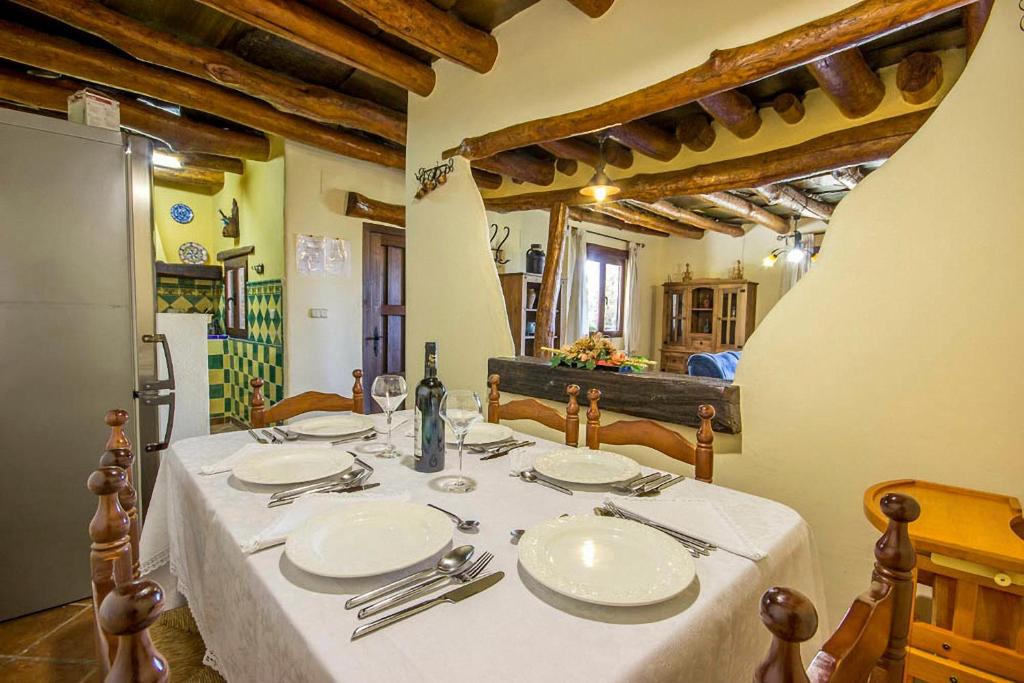 stół z białymi płytami i srebrnymi sztućcami w obiekcie Alpujarra Cortijo Casilla Noguera w mieście Pórtugos