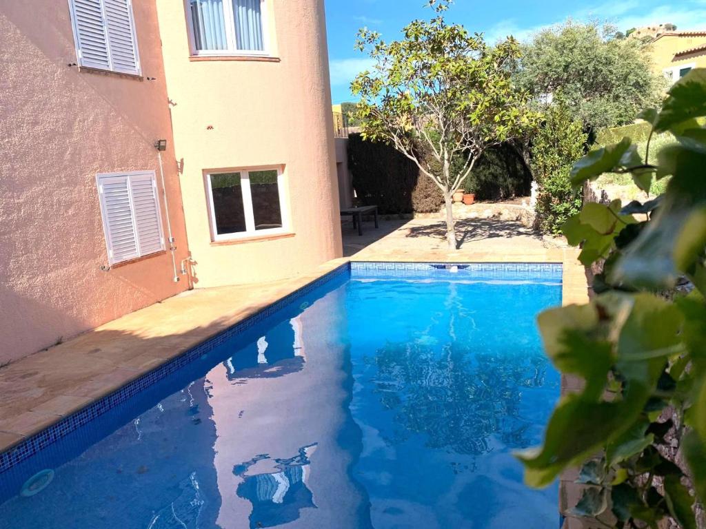 uma piscina azul em frente a uma casa em Villa Begur - Sa Fontansa em Begur