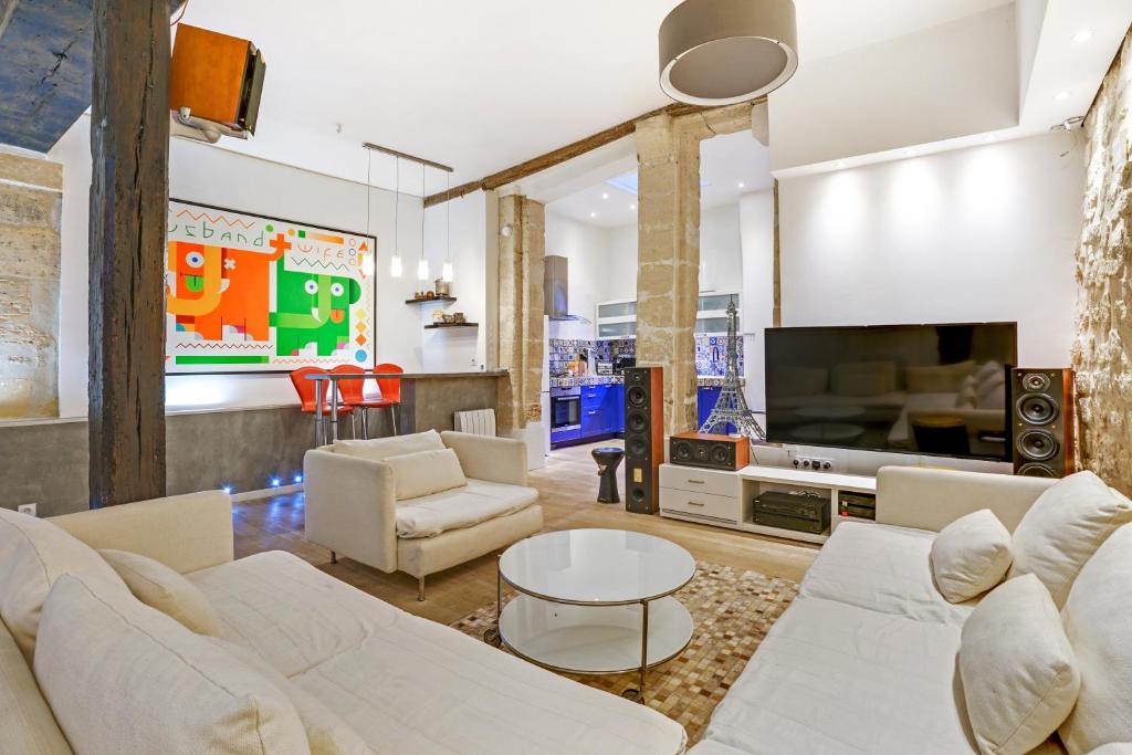 sala de estar con muebles blancos y TV en LUXURY LOFT CENTER OF PARIS, en París