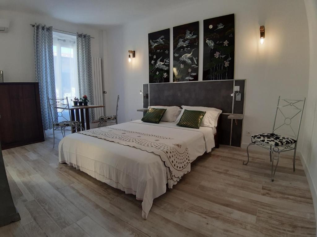 ein Schlafzimmer mit einem großen Bett und einem Stuhl in der Unterkunft Studio Lou Nidou, Nice Centre in Nizza