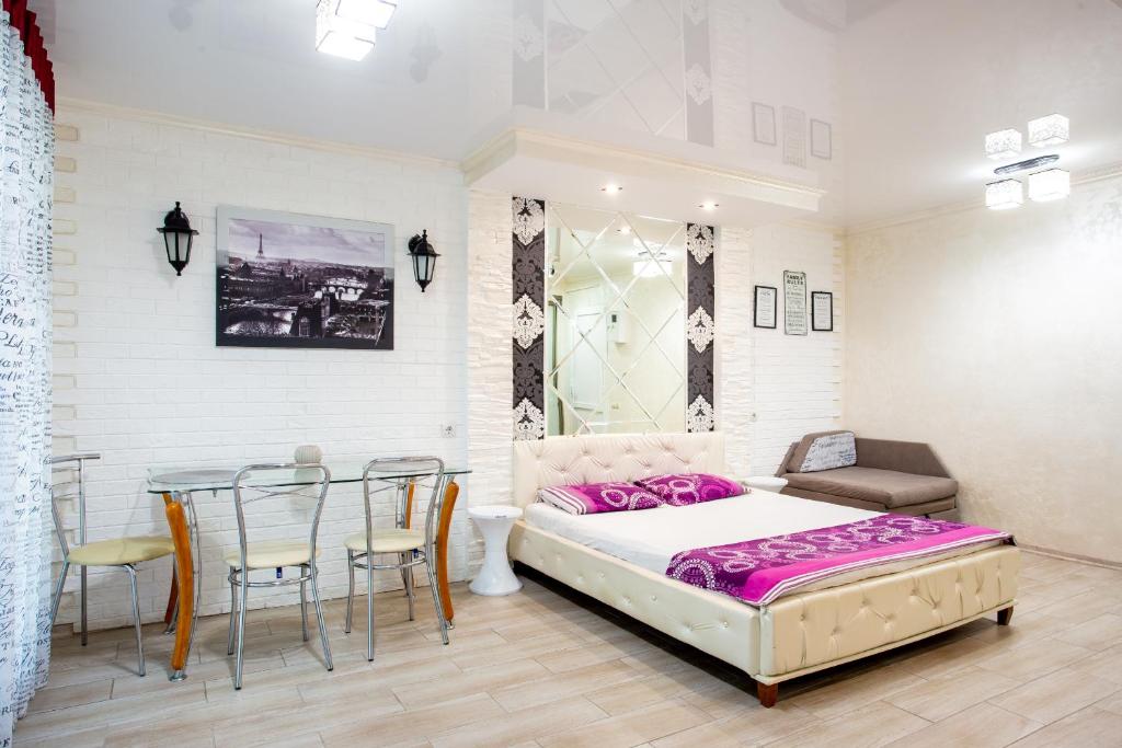 sypialnia z łóżkiem, stołem i krzesłami w obiekcie Studio on Oliinyka Street w mieście Mikołajów