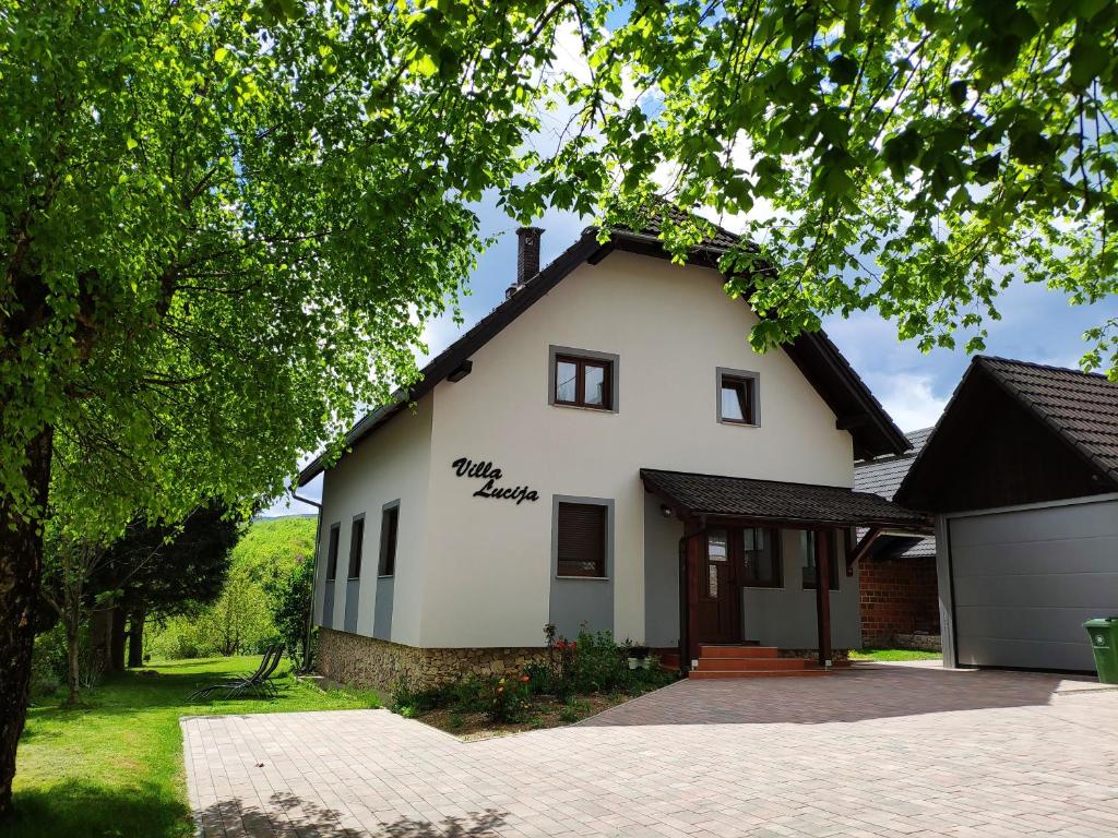 a large white house with a garage at Villa Lucija in Poljanak