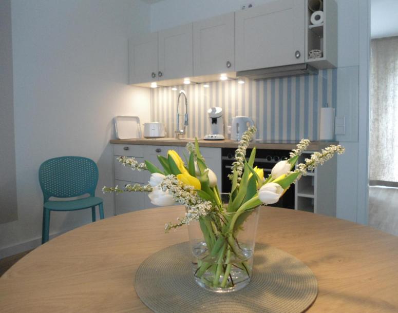 un vase de fleurs sur une table dans une cuisine dans l'établissement SEASIDE APARTMENTS - BEACHHOUSE WAVE, à Eckernförde