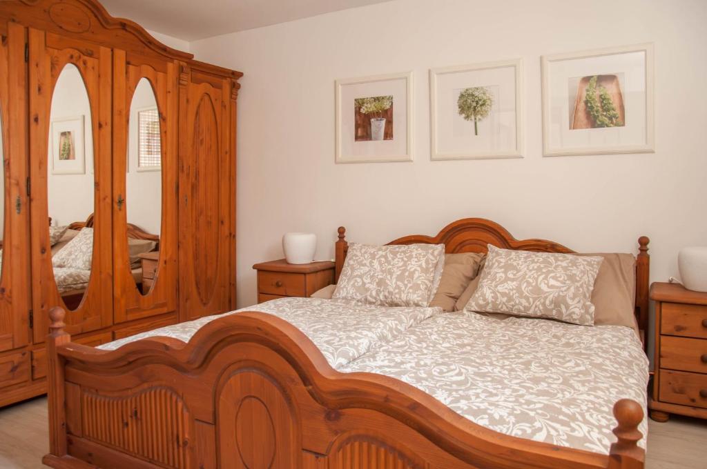 a bedroom with a wooden bed and a mirror at Apartmán Železnice in Železnice