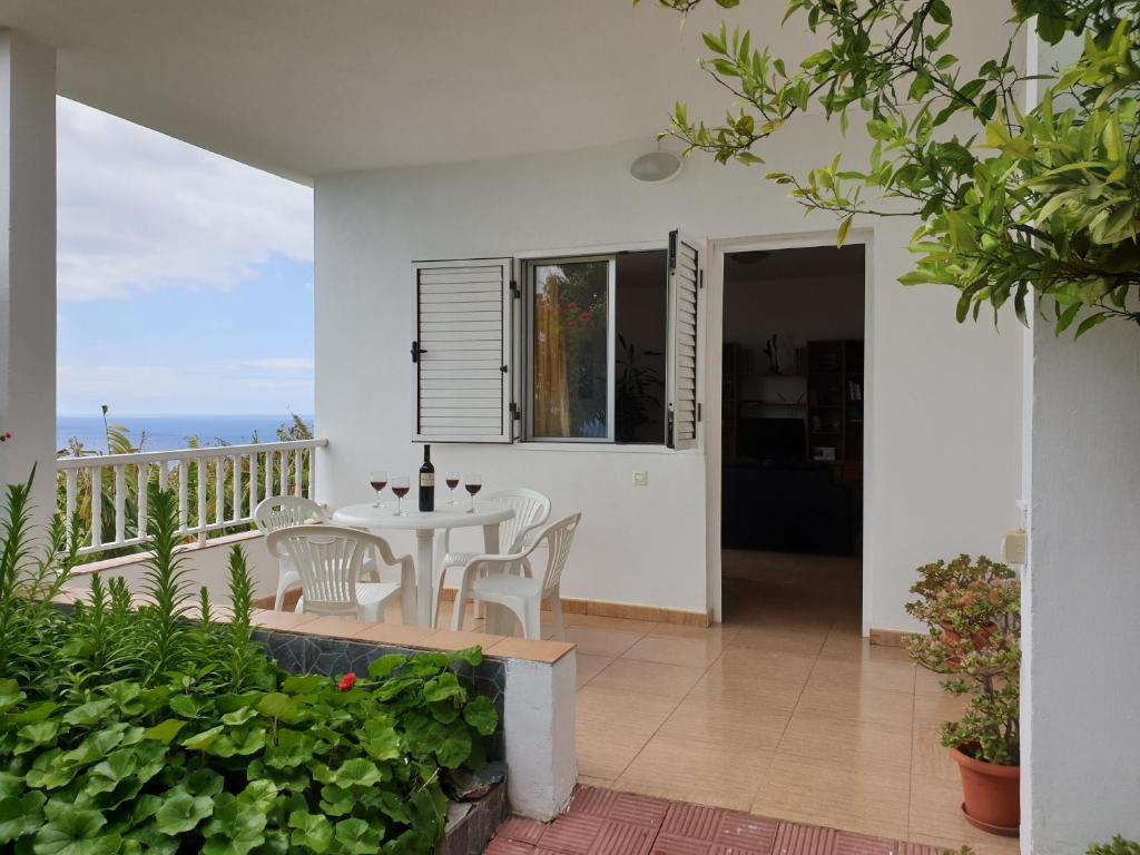 a patio with a table and chairs on a balcony at Casa Angel y Carmen (La Dama, La Gomera) in El Cercado