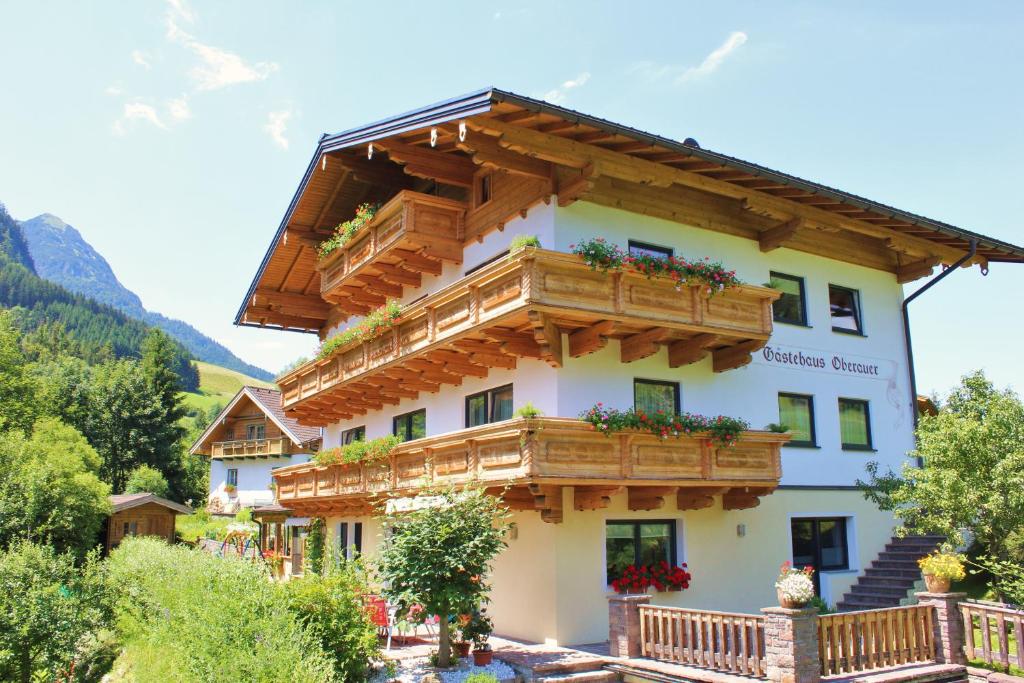 ein Gebäude mit Holzbalkonen und Blumen darauf in der Unterkunft Gästehaus Oberauer in Annaberg im Lammertal