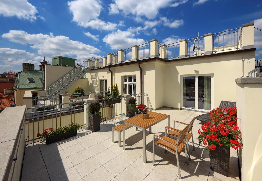 Un patio con una mesa y sillas en un balcón. en Salvator Superior Apartments, en Praga