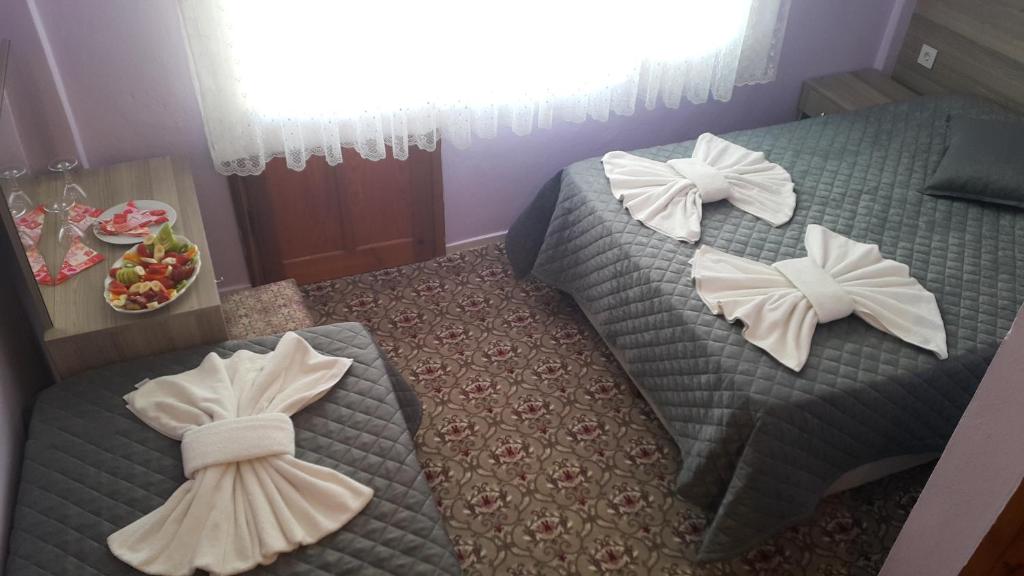 two beds with bows on them in a hotel room at Grand Yayla Hotel in Çeşme