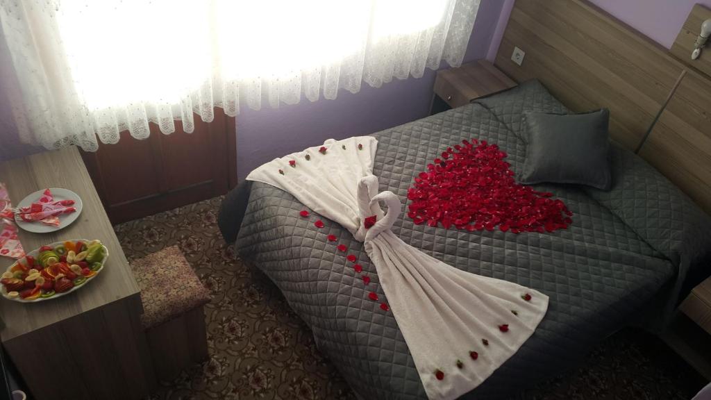 a bedroom with a bed with a heart on it at Grand Yayla Hotel in Çeşme