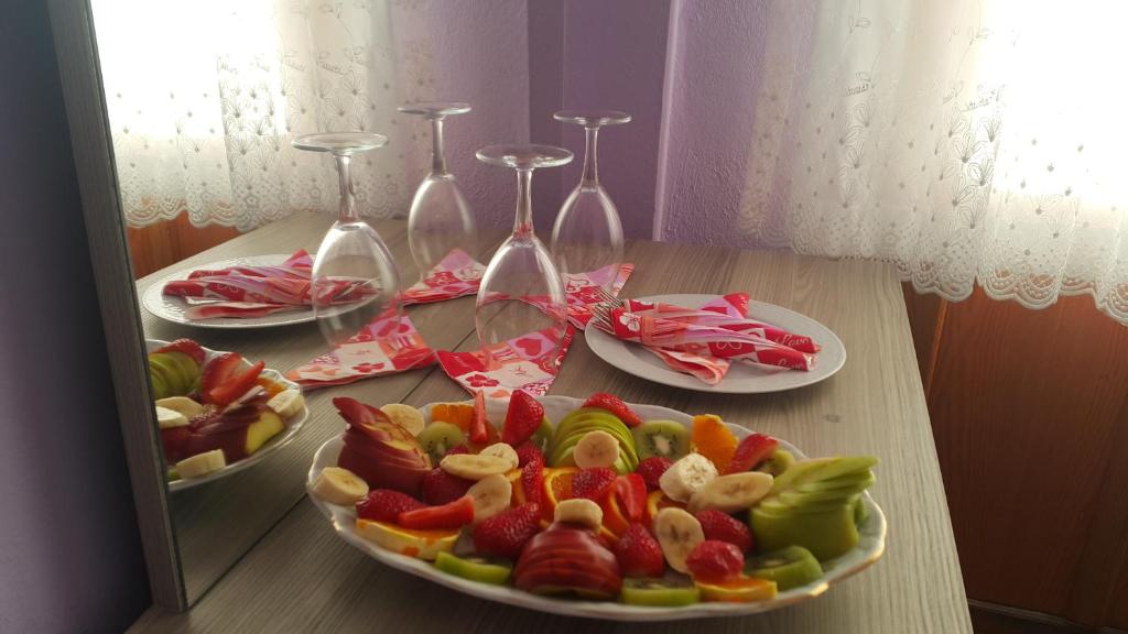 a table with three plates of food and wine glasses at Grand Yayla Hotel in Çeşme