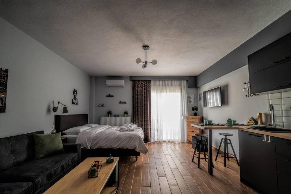 a living room with a couch and a bed and a kitchen at LP Luxury Citycenter Studio in Xanthi