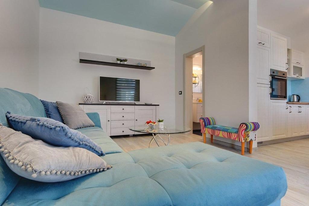 sala de estar con sofá azul y cocina en Villa Sunny Home, en Vodnjan