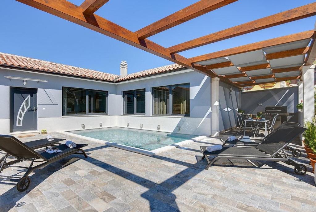 un patio con piscina y una casa en Villa Sunny Home, en Vodnjan