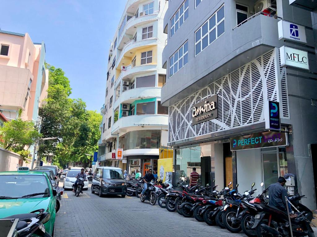 una fila di motociclette parcheggiate sul lato di una strada di Amina Residency a Città di Malé