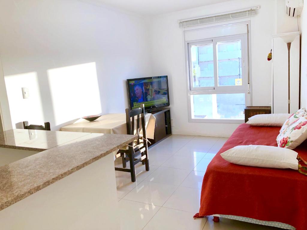 a living room with a table and a dining room at Apart de la Bahía con cochera in Bahía Blanca