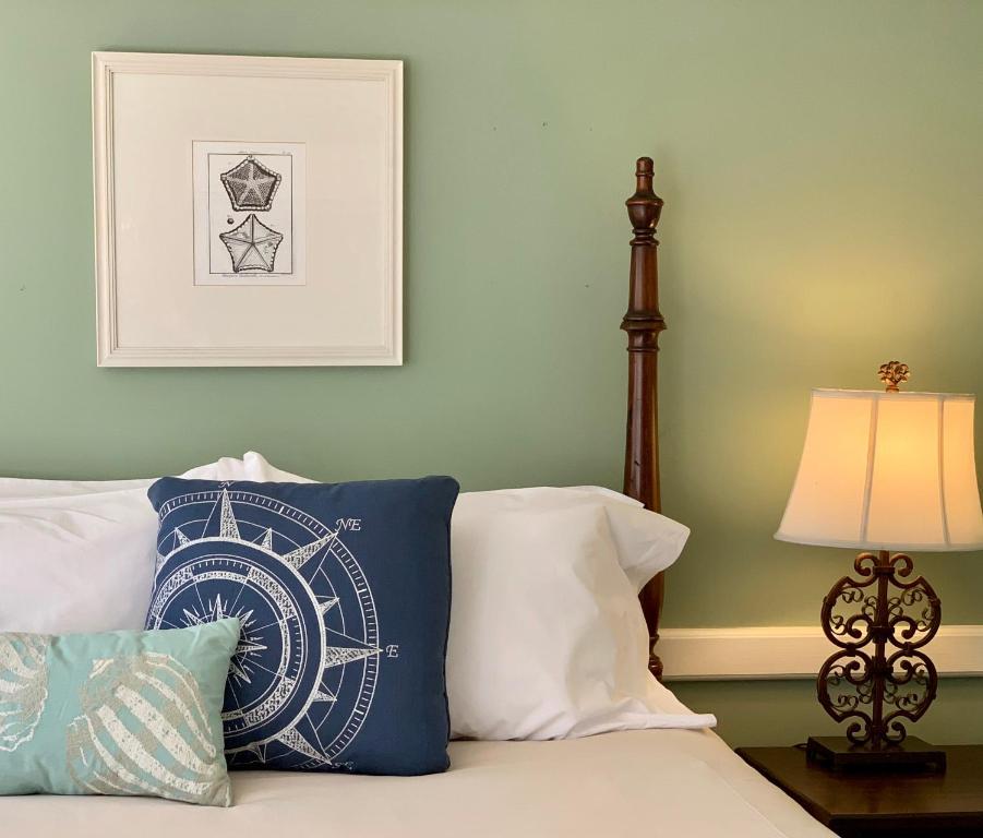 a bed with a clock pillow and a lamp at The Oak Bluffs Inn in Oak Bluffs