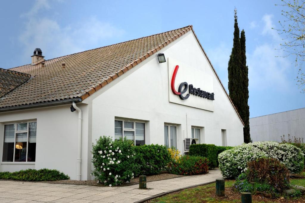 - un bâtiment blanc avec un panneau cazon dans l'établissement Campanile Lyon Est Aéroport Saint Exupery, à Saint-Laurent-de-Mure