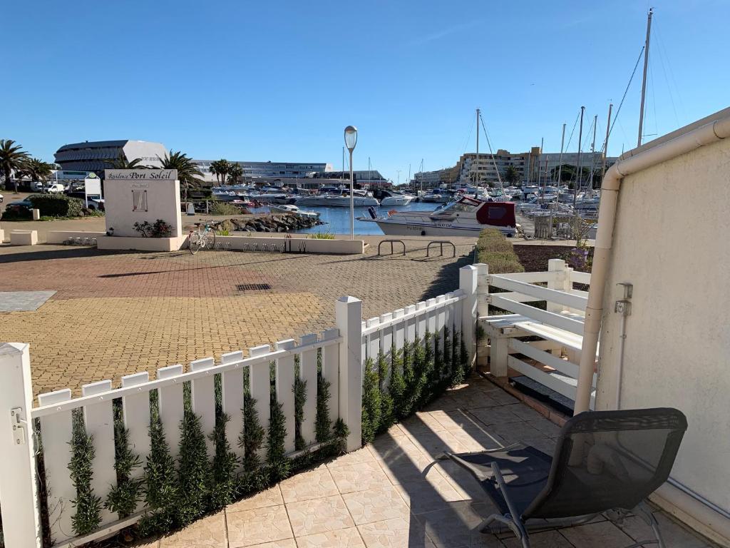 una cerca blanca con una silla junto a un puerto deportivo en MARINA LOVE, en Cap d'Agde
