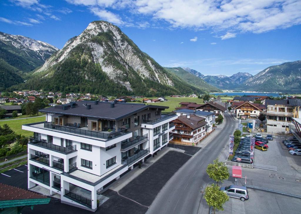 uma vista aérea de uma cidade com montanhas ao fundo em Arthur's Hotel und Apartments am Achensee em Maurach