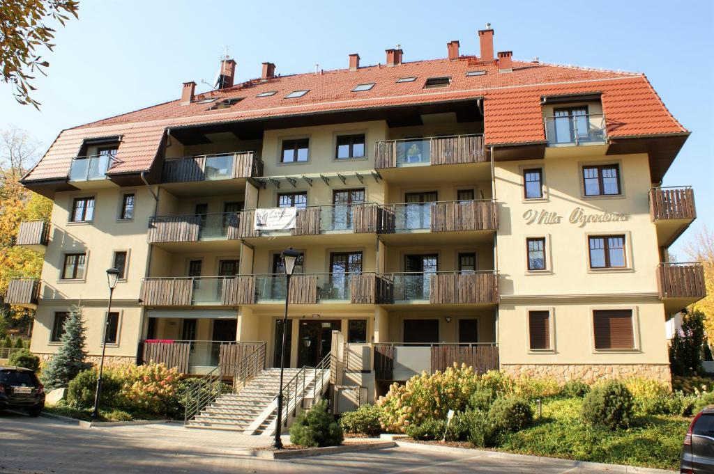 a large apartment building with a red roof at Willa Ogrodowa in Polanica-Zdrój
