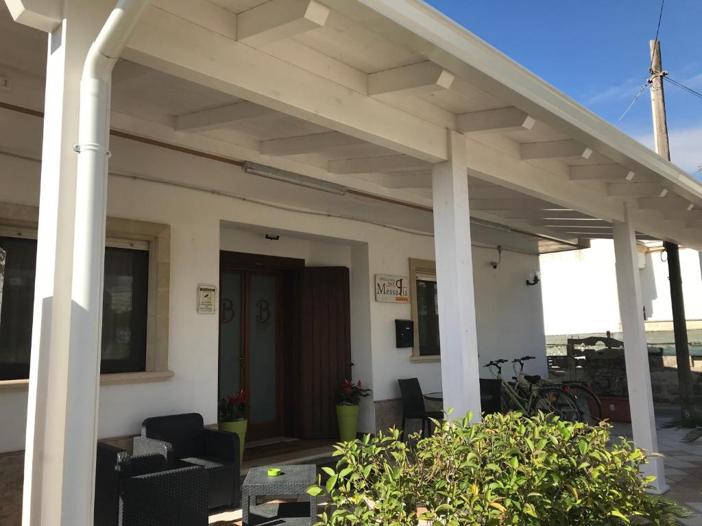 eine Terrasse mit Markise auf einem Haus mit Stühlen in der Unterkunft Messapia in Oria