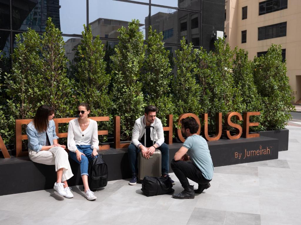 three men and two women are sitting in front of a building at Zabeel House by Jumeirah, The Greens in Dubai
