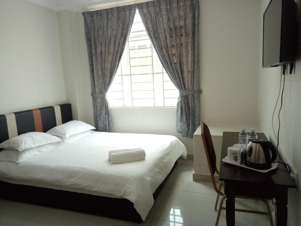 a bedroom with a large bed and a window at Hotel Mutiara KGMMB in Melaka
