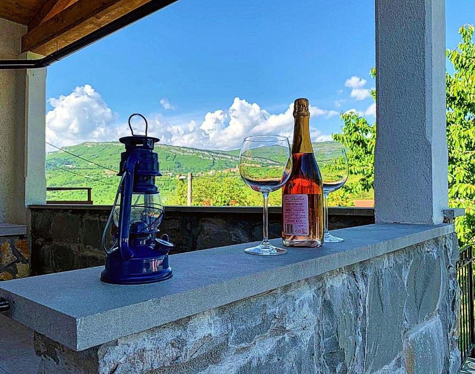 una botella de vino y dos copas en una cornisa en Holiday Home Deni, en Roč
