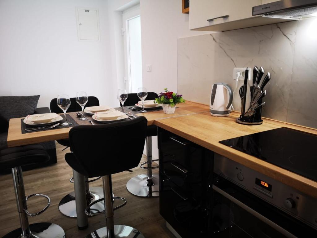 a kitchen with a table with wine glasses on it at Apartment Skavo in Baška Voda