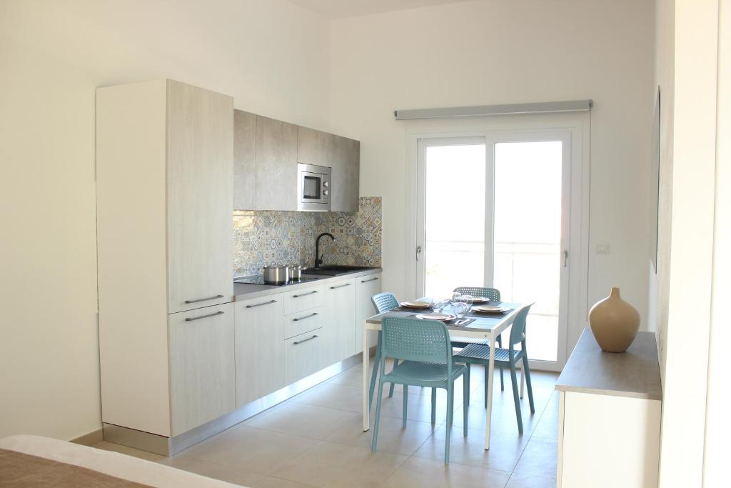 uma cozinha com uma mesa e uma sala de jantar em 197 Pozzo San Nicola em Stintino