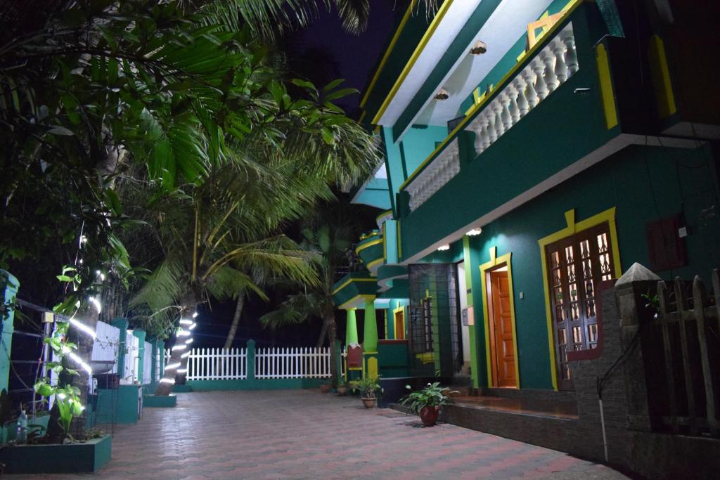 un edificio colorido con una pasarela delante de él en Beach Village Holiday Homes Goa en Colva