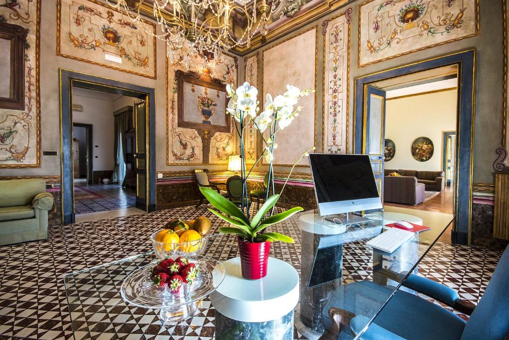 a living room with a glass table with a laptop at VILLA DURANTE in Ercolano
