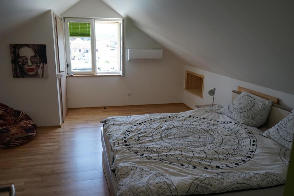 sypialnia z dużym łóżkiem i oknem w obiekcie Pascal Villa 7 nights 1 free w mieście Stari Grad