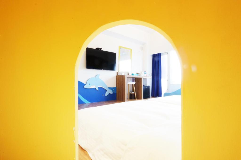 a room with a bedroom with a dolphin painted on the wall at 36 Lighthouse in Hualien City