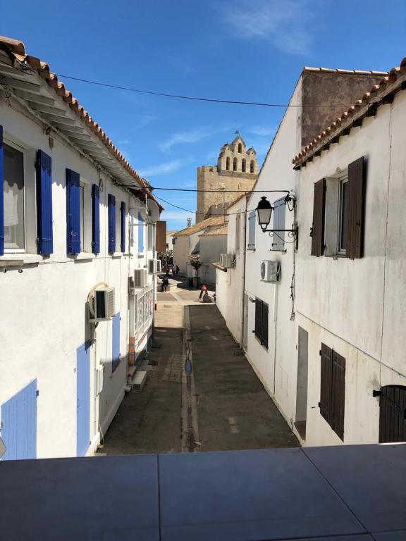 eine Gasse zwischen zwei Gebäuden mit einem Gebäude im Hintergrund in der Unterkunft Bellevue in Saintes-Maries-de-la-Mer