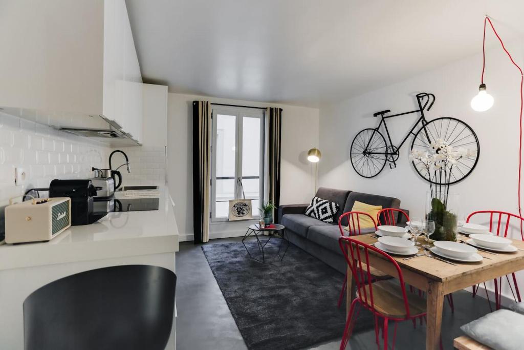 uma cozinha e uma sala de estar com uma mesa com uma bicicleta na parede em Charming House for 6 people - Louvre & Opera em Paris