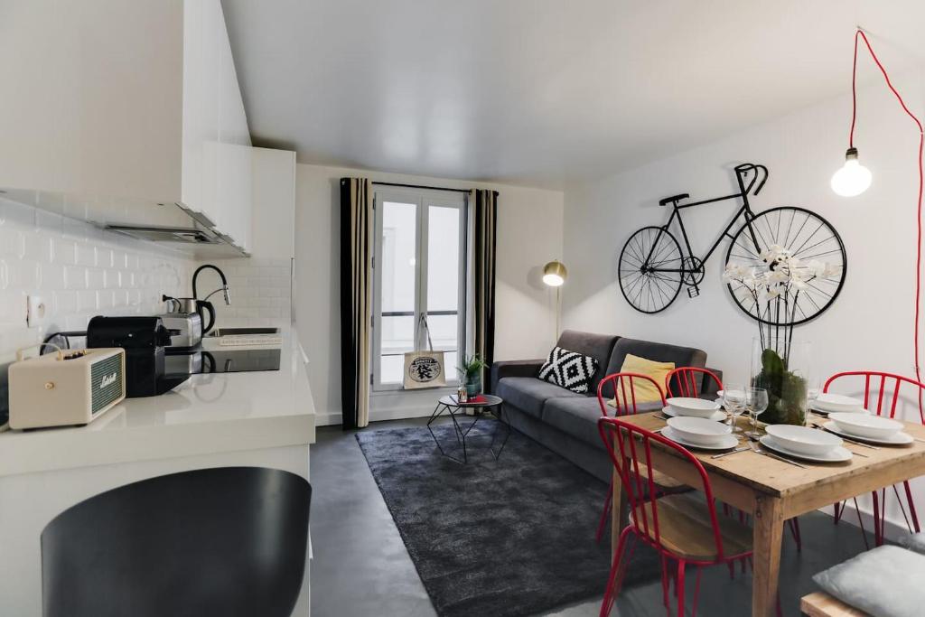 une cuisine et un salon avec une table et un vélo sur le mur dans l'établissement Charming House for 6 people - Louvre & Opera, à Paris