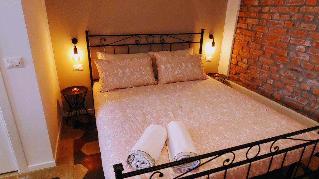 um quarto com uma cama com duas almofadas e uma parede de tijolos em B&B El Brumista em Milão