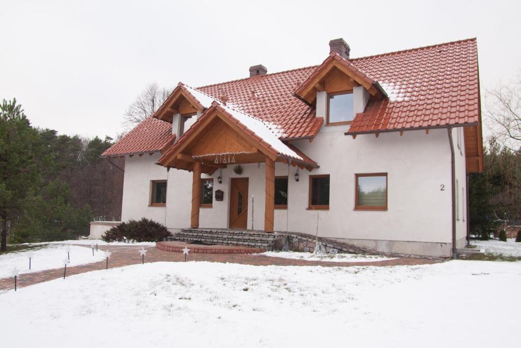 uma casa branca com um telhado vermelho na neve em Agro-Wda em Czarna Woda