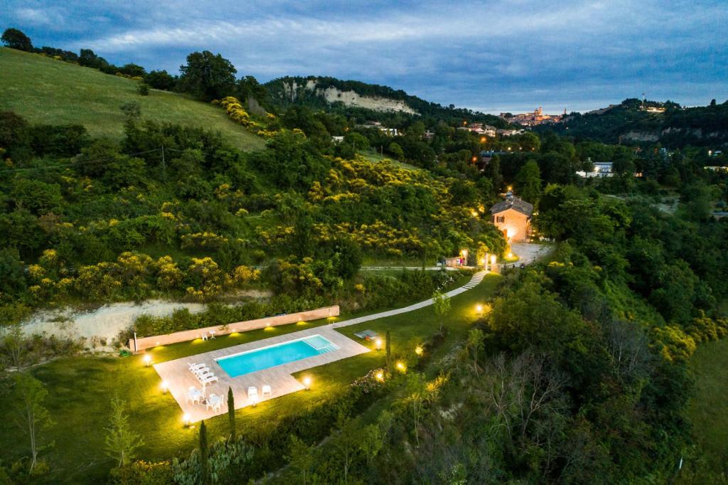 eine Luftansicht einer Villa mit einem Pool auf einem Hügel in der Unterkunft Ca' Maggetti in Urbino